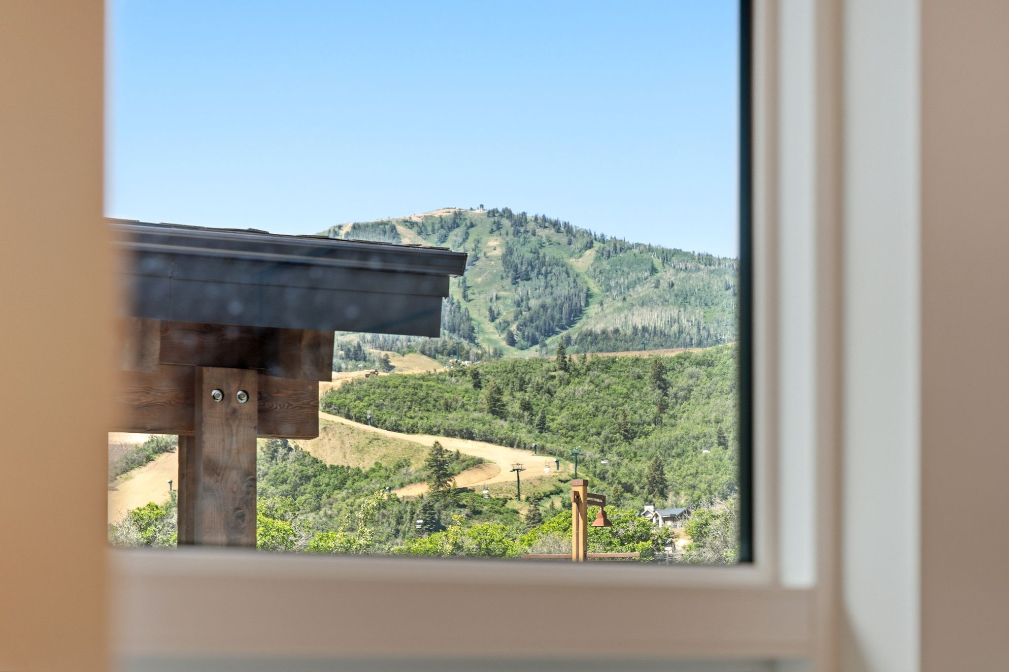 Window framing a mountain landscape with verdant slopes