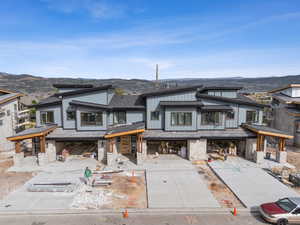 View of front of house with board and batten siding, a mountain view, roof with shingles, a patio area, and a gazebo
