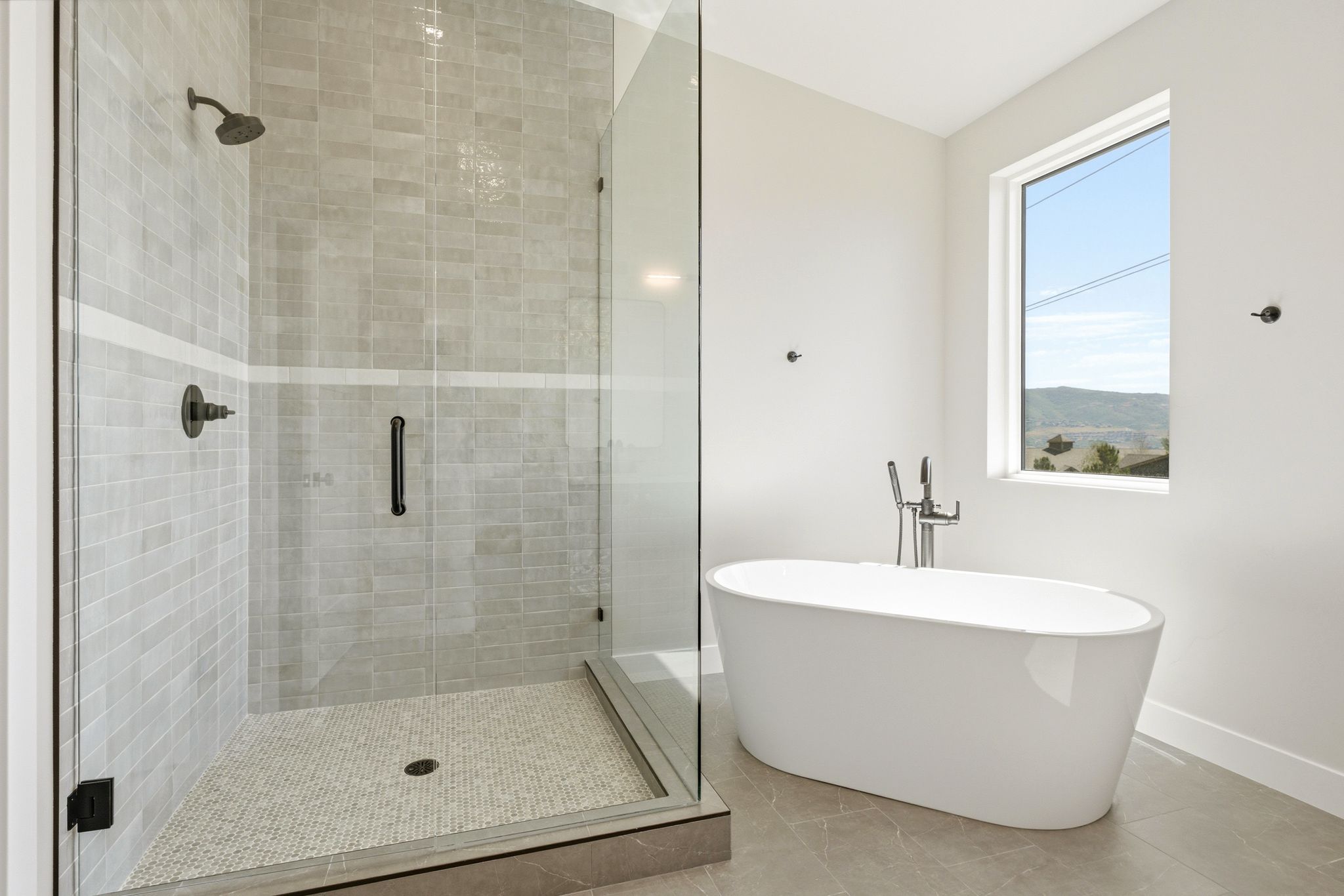 Contemporary bathroom featuring a spacious walk-in shower with light-toned tilework and dark bronze fixtures
