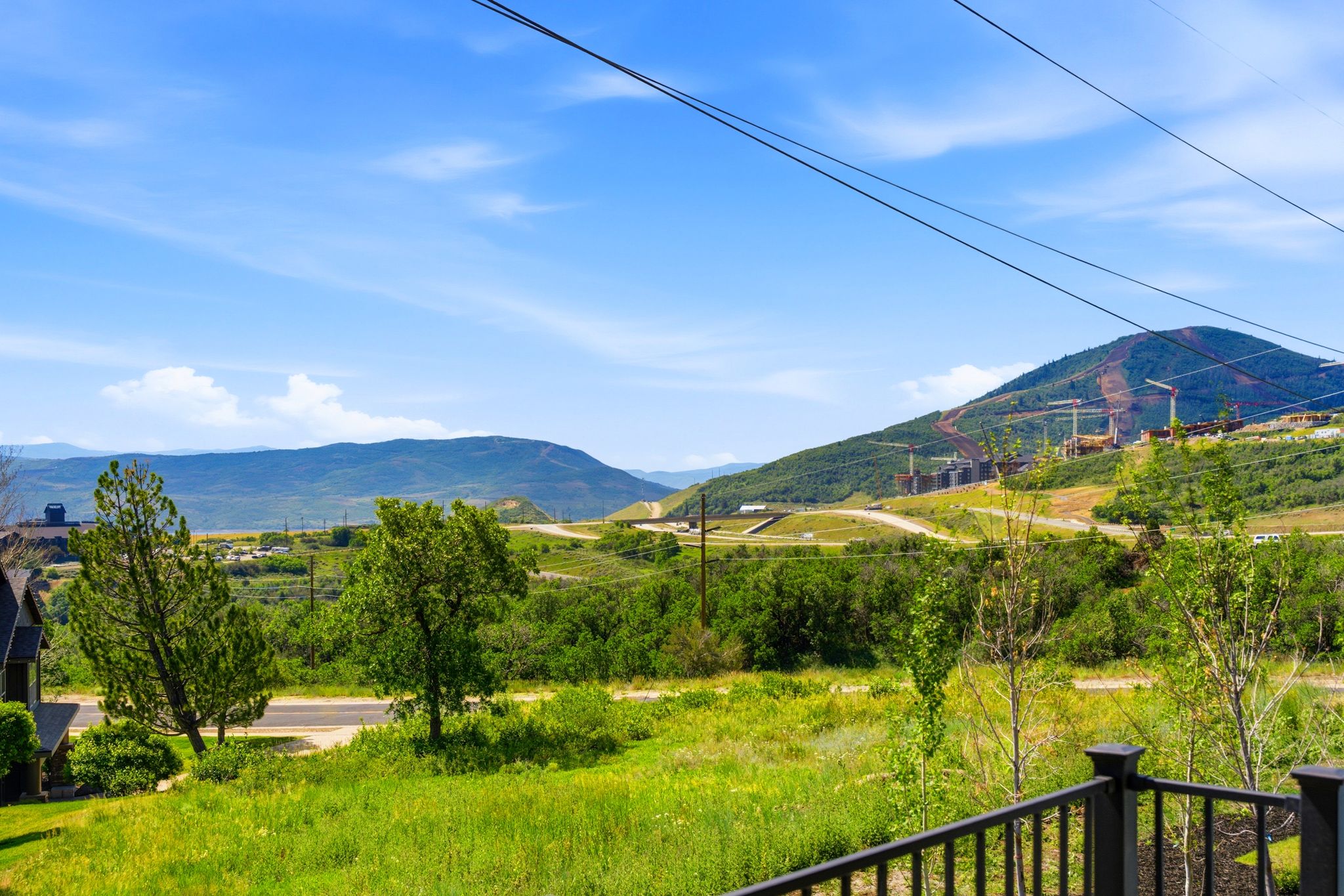 Expansive mountain and valley scenery featuring distant peaks and a partially developed hillside