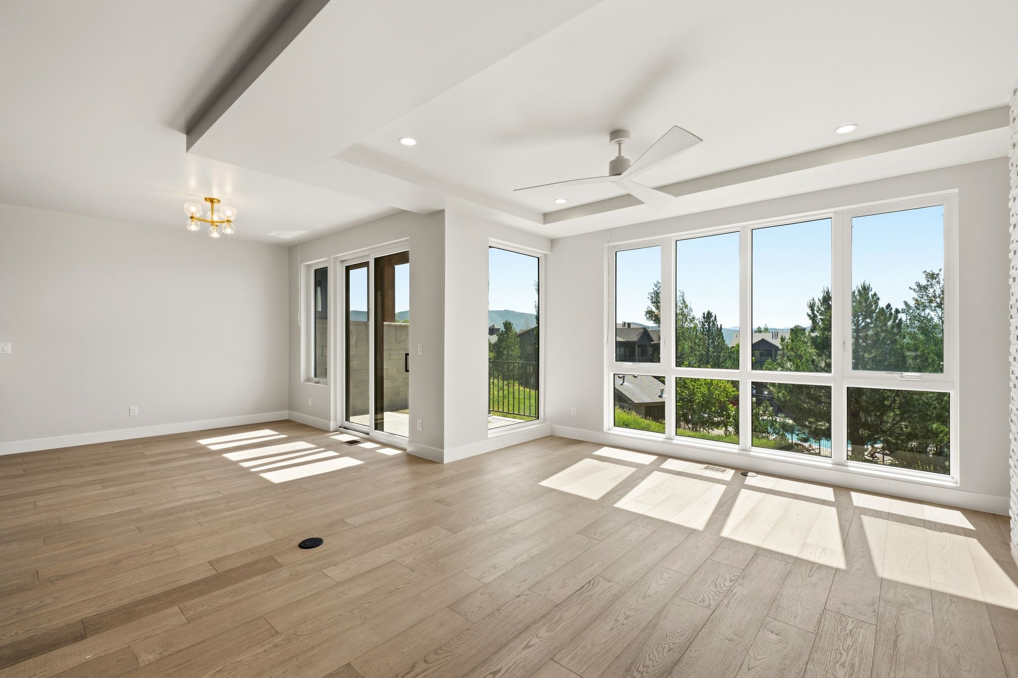 Spacious room featuring light wood-finish flooring and large windows
