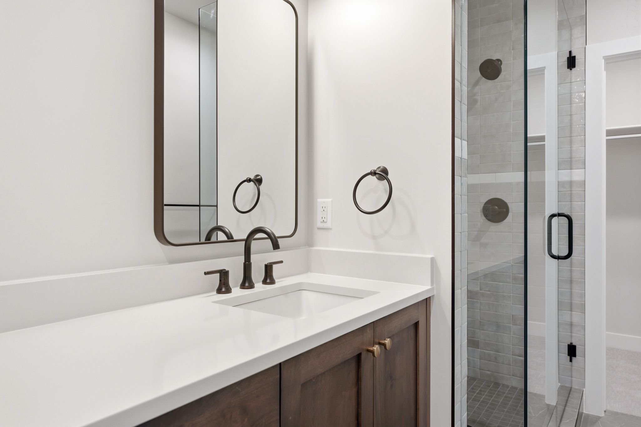 Bathroom vanity featuring a quartz countertop, integrated rectangular sink, and dark bronze-finish fixtures