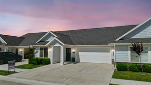 View of front of property featuring driveway, an attached garage, board and batten siding, and roof with shingles