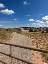 View of dirt / gravel driveway featuring a view of countryside
