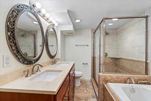 Bathroom with double vanity, a bath, a shower stall, a textured ceiling, and toilet