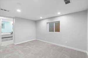 Spare room featuring recessed lighting, carpet, and baseboards