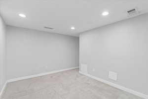 Spare room with recessed lighting, carpet, and baseboards