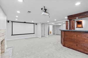 Cinema with light carpet, a bar, recessed lighting, and baseboards