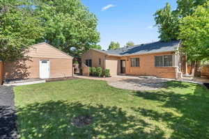 Back of property with brick siding and a patio area