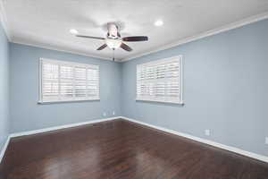 Empty room featuring ceiling fan, baseboards, wood finished floors, ornamental molding, and recessed lighting