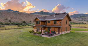 Rear view of house featuring a patio, gas fireplace, and a mountain view