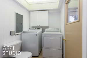 Laundry room featuring electric panel and separate washer and dryer