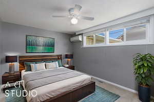 Carpeted bedroom featuring a wall mounted AC, baseboards, and ceiling fan