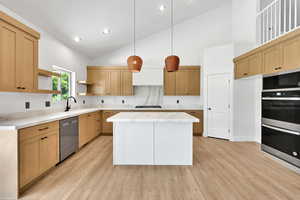 Kitchen with appliances with stainless steel finishes, open shelves, light wood-style floors, high vaulted ceiling, and light countertops