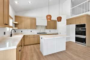 Kitchen featuring a sink, gas stovetop, high vaulted ceiling, double wall oven, and open shelves