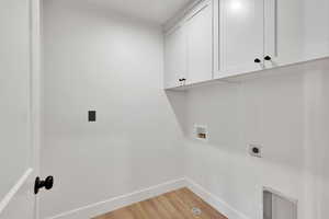 Laundry room featuring electric dryer hookup, baseboards, cabinet space, light wood-style flooring, and hookup for a washing machine