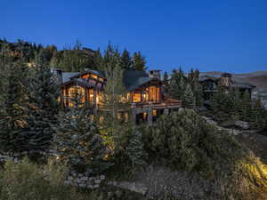 Back of property featuring a chimney and stone siding