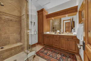 Bathroom featuring a stall shower, double vanity, and light tile patterned floors