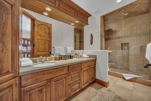 Bathroom with a shower stall, double vanity, and recessed lighting