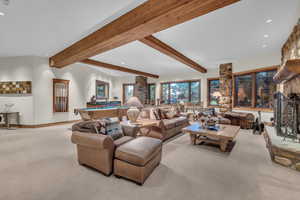 Living room featuring carpet floors, billiards, beam ceiling, recessed lighting, and a stone fireplace