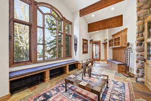 Living room with stone tile floors, recessed lighting, and lofted ceiling