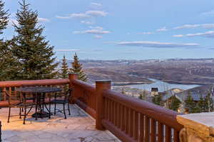 Wooden deck featuring a water and mountain view, outdoor dining area, and a patio area