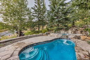 Outdoor pool featuring a patio and an in-ground hot tub