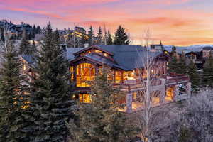 Property exterior at dusk featuring a shingled roof and a chimney