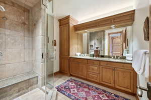 Full bath featuring a shower stall, vanity, and light tile patterned floors