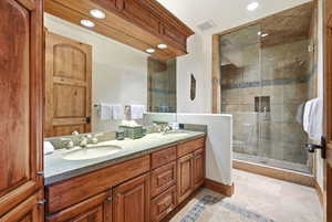Bathroom with double vanity, a shower stall, recessed lighting, and light tile patterned flooring
