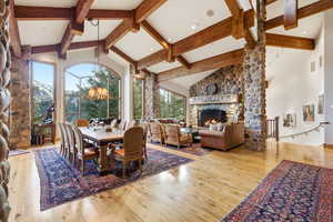 Dining space with a high ceiling, light wood-style flooring, and a fireplace