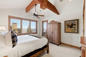Bedroom with light carpet, beam ceiling, and a ceiling fan