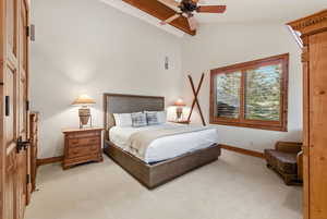 Bedroom with a ceiling fan, light carpet, and lofted ceiling with beams