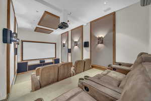 Home theater with carpet floors and a wall mounted air conditioner
