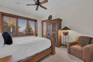Carpeted bedroom with a ceiling fan and recessed lighting