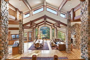 Living area with light wood-type flooring, a fireplace, decorative columns, and recessed lighting