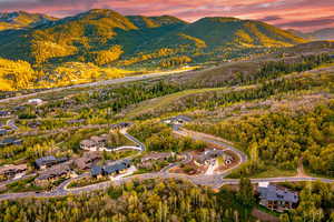 Aerial view of property and surrounding area featuring mountains and a heavily wooded area