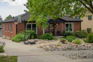 View of front facade featuring a tiled roof, brick siding, and concrete driveway