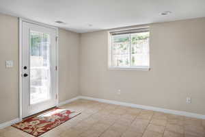 Entryway featuring baseboards and light tile patterned floors
