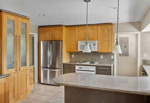 Kitchen with white appliances, electric panel, light tile patterned floors, decorative backsplash, and glass insert cabinets