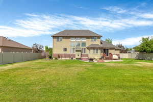 Back of property with brick siding, stucco siding, entry steps, a shingled roof, and a patio area