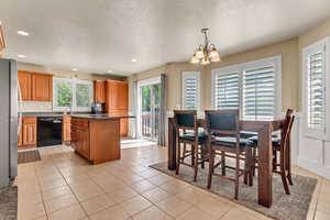 Dining room with a chandelier, light tile patterned floors, recessed lighting, and a textured ceiling