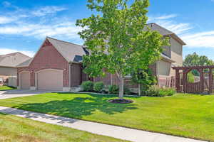 View of front of home with brick siding, concrete driveway, a garage, and roof with shingles