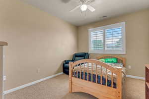 Carpeted bedroom with baseboards and a ceiling fan