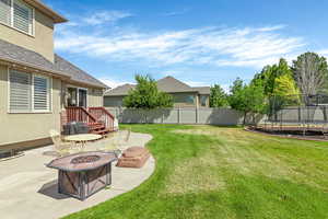 View of yard with a patio area, a trampoline, and an outdoor fire pit