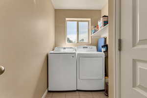 Laundry area featuring washer and dryer and light tile patterned flooring