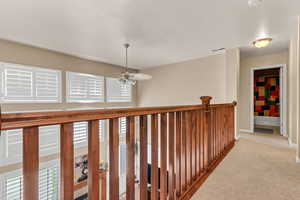 Hallway with carpet floors and baseboards