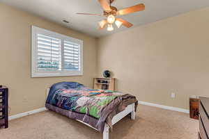 Bedroom featuring carpet, baseboards, and a ceiling fan