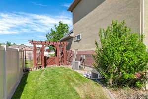 View of yard featuring a gate, a pergola, and central AC