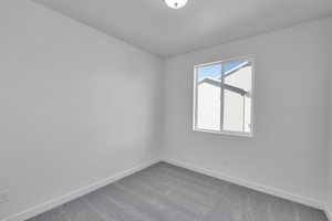 Carpeted empty room featuring baseboards